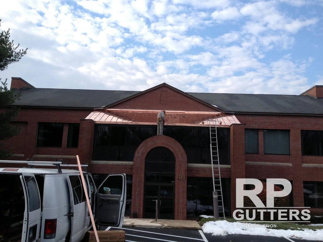 Brick commercial building with a copper entry roof