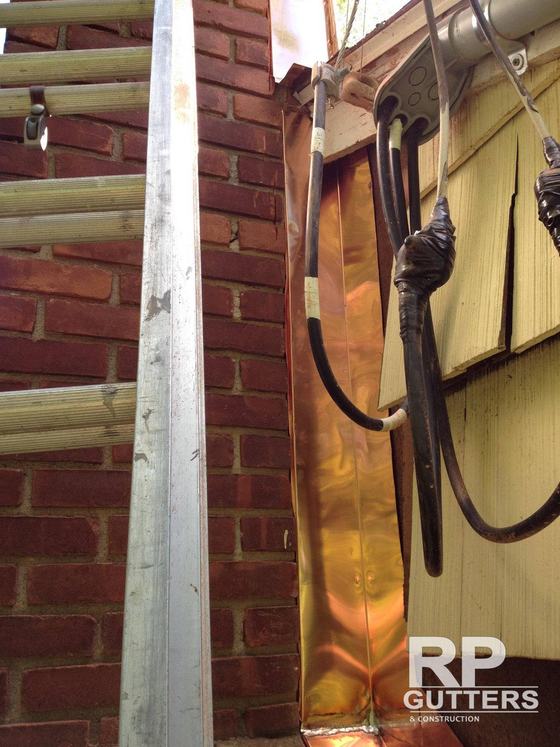 Downspout running down a brick wall