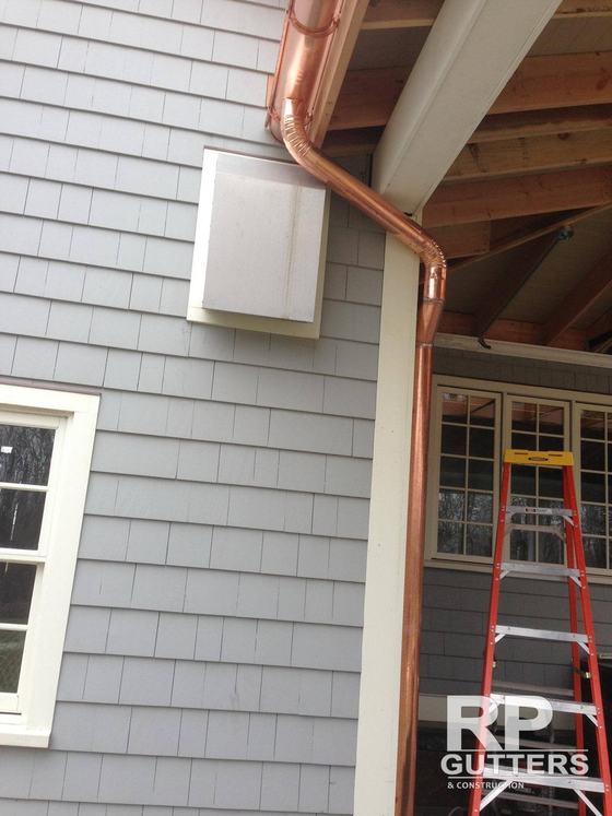 Copper gutter at a shingled eave