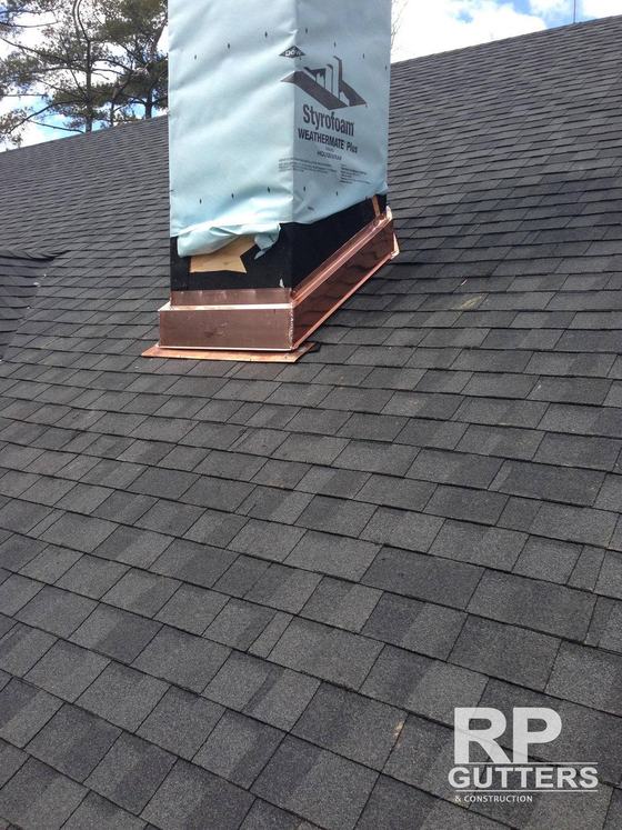 Copper chimney curb on a shingle roof