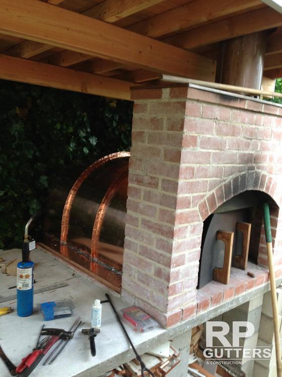 Copper hood over a brick fireplace