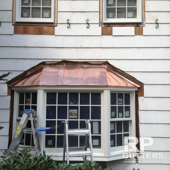 Copper bay window roof with a ladder in place