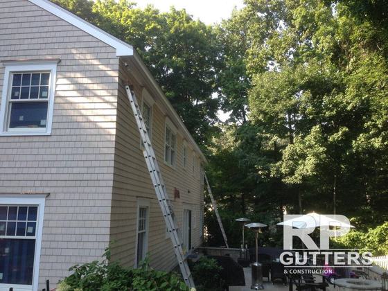 Ladder set along a shingled home for gutter work