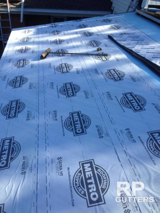 Blue roof underlayment rolled across a deck
