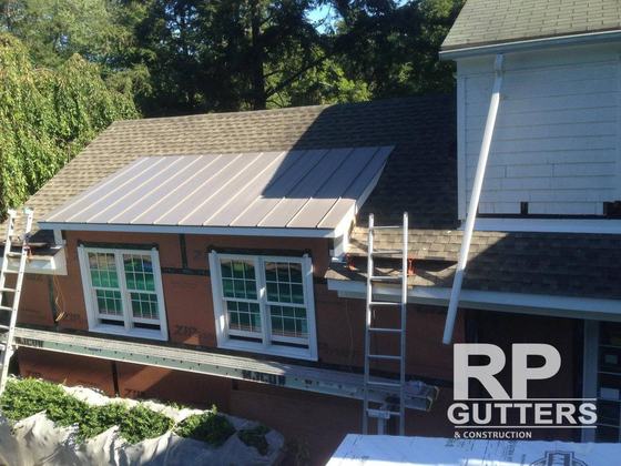 Metal roof over a dormer with ladders at the eave