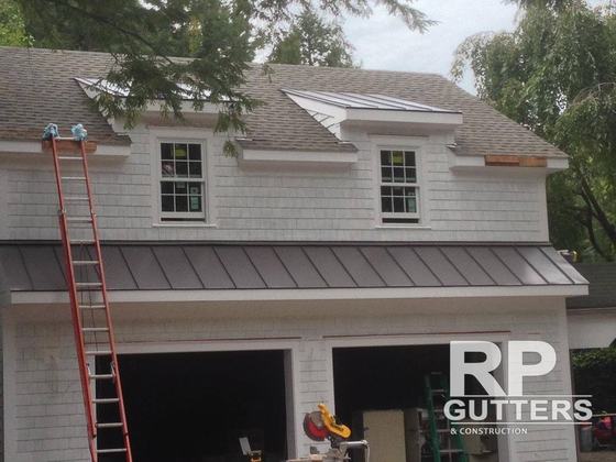 Metal roof over a garage with a ladder in place