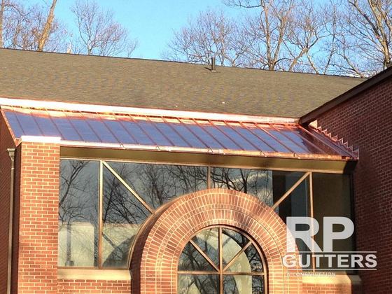 Copper standing-seam roof over a brick sunroom