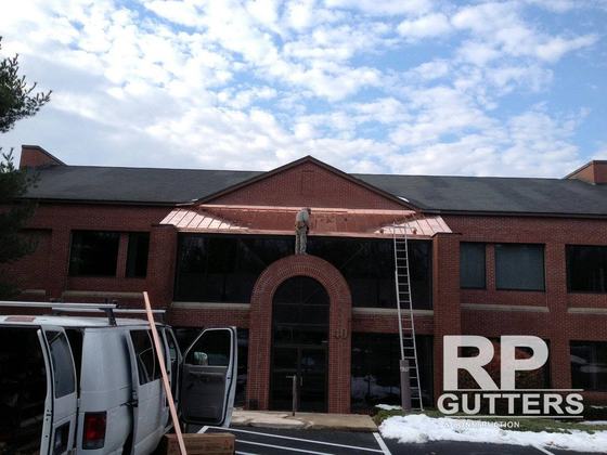 Brick commercial building with a copper entry roof