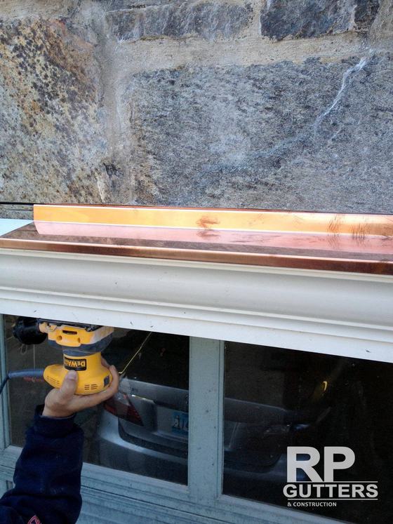 Copper-capped gutter on a white fascia