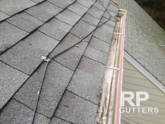 Gutter along a shingle roof edge