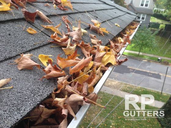 Gutter full of fall leaves before cleaning
