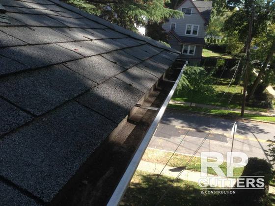 Gutter running along a shingle roof edge